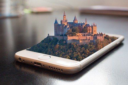 A smart phone with a castle on the screen is sitting on a table.